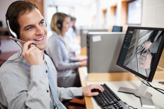 Smiling,Assistant,Using,A,Headset,In,A,Call,Center